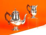 deux théières en argent posées sur un socle transparent