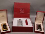 trois types de parfums différents dans une boîte rouge posée sur une surface grise