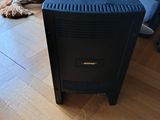 a black stove sitting on a wooden floor in a living room