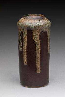 un vase marron et noir sur lequel on voit une coulure de peinture