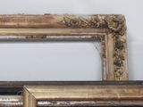 two old picture frames sitting on a shelf next to each other