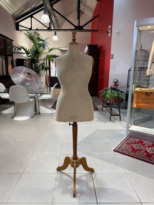 a mannequin on a stand in the middle of a room