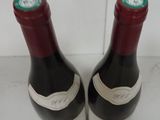 two bottles of wine sitting on top of a counter next to each other