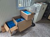 un ventilateur posé à côté de quelques cartons