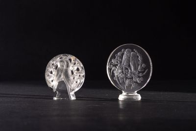two clear glass figurines sitting on top of a black table