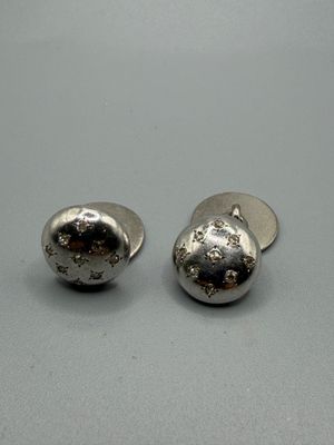 paire de boucles d'oreilles à clous en argent sterling sur un fond gris