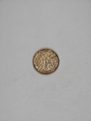a close up of a gold coin on a white surface