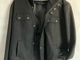 an image of a jacket hanging on a hanger on a bed