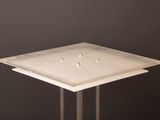 a small square table with a metal base on a black background
