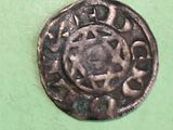 a silver coin with a star on it on a green surface