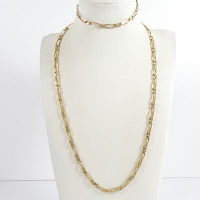 a white mannequin torso with a gold chain necklace on it