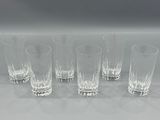 six glasses are lined up in a row on a white surface