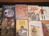beaucoup de livres posés sur un tapis, par terre