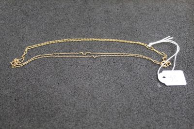 un collier en or auquel est attachée une médaille