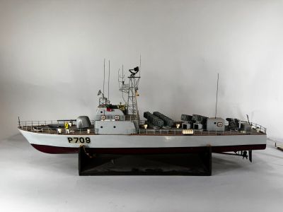 une maquette de bateau exposée dans une pièce blanche