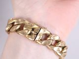 gold chain bracelet on a woman ' s wrist with a gold clasp