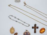 several pieces of jewelry including a cross, a locke, and a necklace
