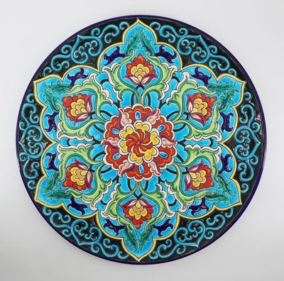 une assiette décorée d'un motif coloré, posée sur une table
