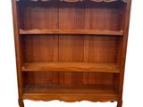 une photo d'une bibliothèque en bois surmontée d'une étagère