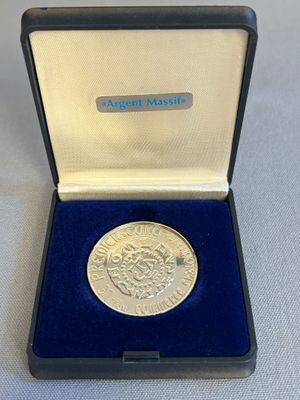 un gros plan d'une pièce d'argent dans une boîte bleue