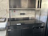 une cuisine en acier inoxydable équipée d'un réfrigérateur et d'une cuisinière
