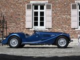 a blue sports car parked in front of a brick building