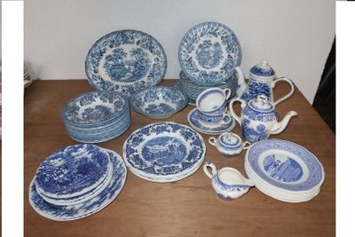many blue and white plates and cups on the table