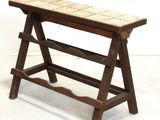a wooden bench with a tile top on a white floor