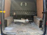 the back end of a van with the door open and a bed in the back