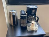 une petite table sur laquelle se trouvent une cafetière et une tasse