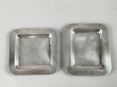 pair of silver plated square trays on a white surface