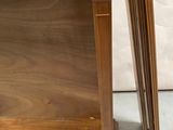a wooden table with a shelf on top of it next to a white wall
