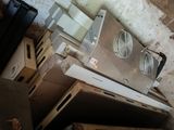 un vieux poêle surmonté d'un ventilateur, dans une pièce sale