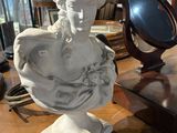 un buste de femme assise sur une table, avec un miroir