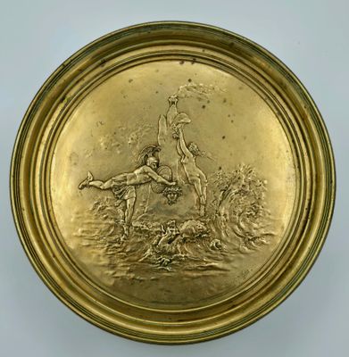 une image représentant une assiette en or sur laquelle figurent une femme et un chien