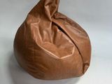 brown leather bean bag sitting on a white surface