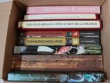 many books in a box that are stacked on top of each other