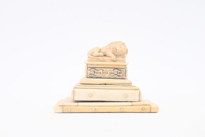 a small statue of a lion on top of a pile of books