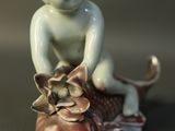a figurine of a baby sitting on a fish