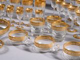 a lot of gold and clear glassware on a table