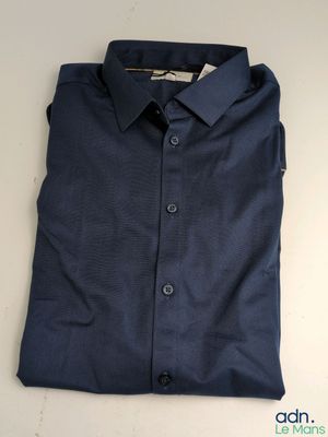 une chemise bleue posée sur une table blanche
