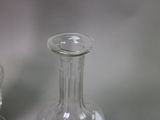 a clear glass bottle sitting on a table next to a salt shaker
