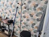 une photo d'une pièce avec un mur tapissé et un tabouret