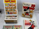 Des bandes dessinées de Mickey Mouse et d'autres personnages sont posées sur une table