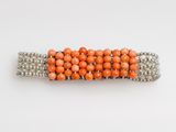 un gros plan d'une barrette à perles orange sur fond blanc