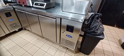 une cuisine avec tout un tas d'appareils électroménagers et un sac poubelle posé sur le plan de travail
