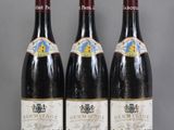 trois bouteilles de vin sont alignées sur une table