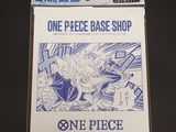 a close up of a card game with one piece base shop on it