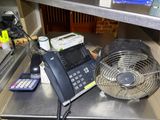 a phone and a fan on a counter in a kitchen