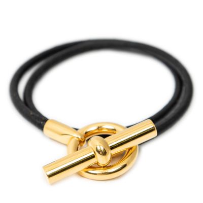 un gros plan d'un bracelet en cuir noir avec un fermoir doré